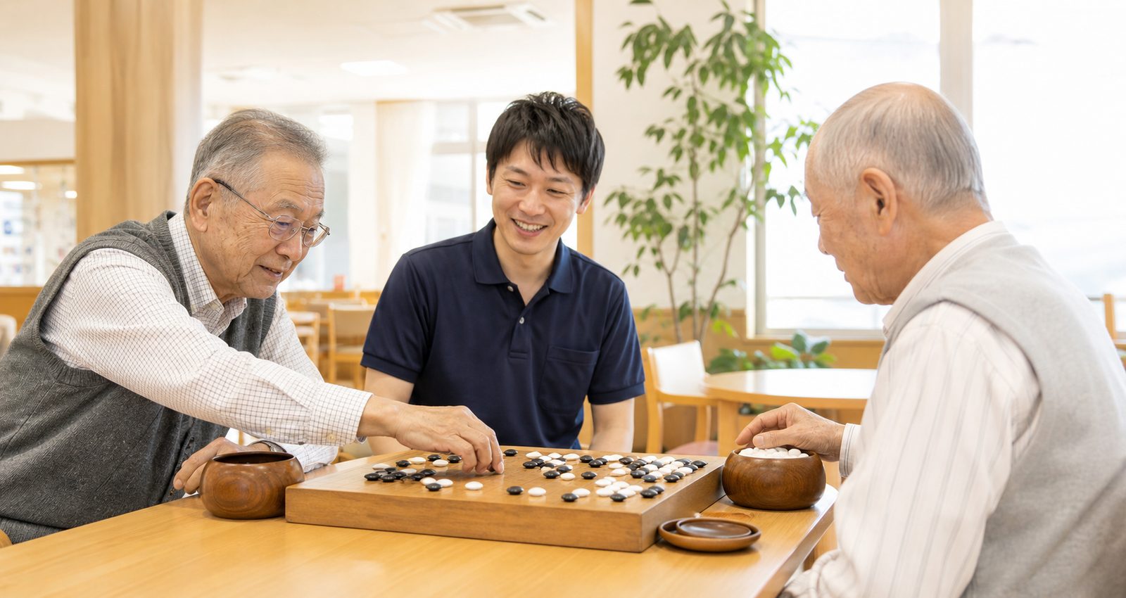 囲碁を楽しむ利用者とそばで見守るスタッフ（※実際の写真に差し替えます）